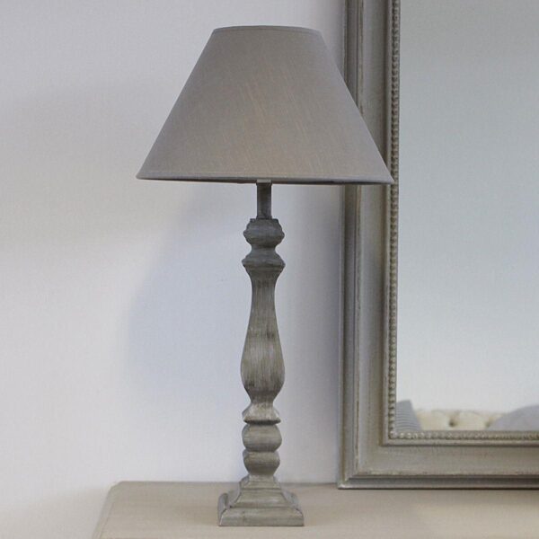 Table Lamp with Grey Linen Shade on a table next to a mirror.