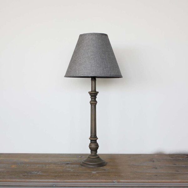Dark table lamp with grey textured shade standing on a table.