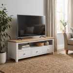 Florence large white painted TV unit with a natural wood top, featuring a wide open media shelf and three storage drawers with round knobs, styled in a living room holding a flat-screen television.