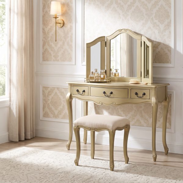 A French-inspired gold dressing table set with curved cabriole legs. The table features three drawers with dark handles, topped with a three-way mirror and paired with a cream upholstered stool.