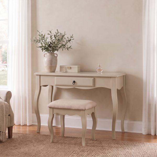 Romance beige dressing table and stool set featuring French Rococo curved legs, a central drawer with an antique brass handle, and a softly padded vanity seat, styled with a rustic vase of greenery.